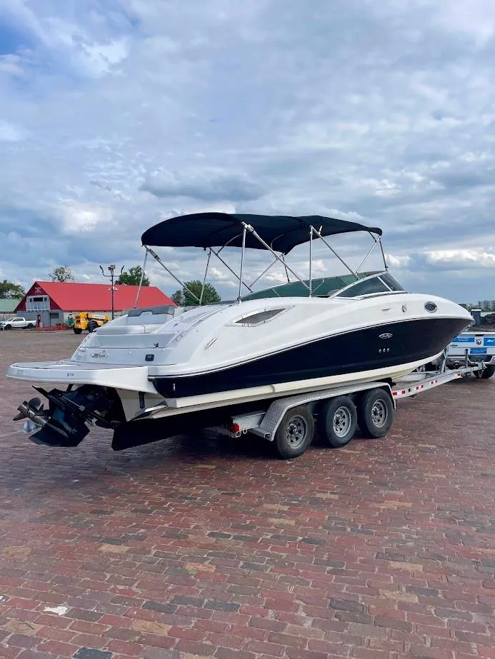 Slide: The Image of 2010 Sea Ray 300 Sundeck boat on a trailer, parked on a brick surface. - 3