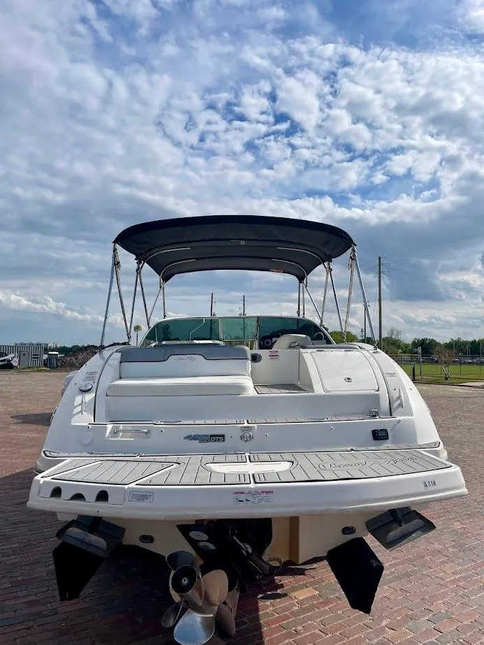Slide: The Image of 2010 Sea Ray 300 Sundeck boat with canopy, docked under a partly cloudy sky. - 4