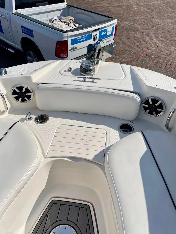 Slide: The Image of 2010 Sea Ray 300 Sundeck boat interior with seating and speakers, parked near a pickup truck. - 9