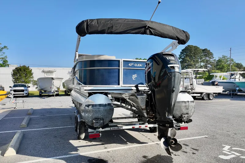 Slide: The Image of 2022 Cypress Cay Seabreeze 232 pontoon boat with Mercury outboard motor in parking lot. - 2