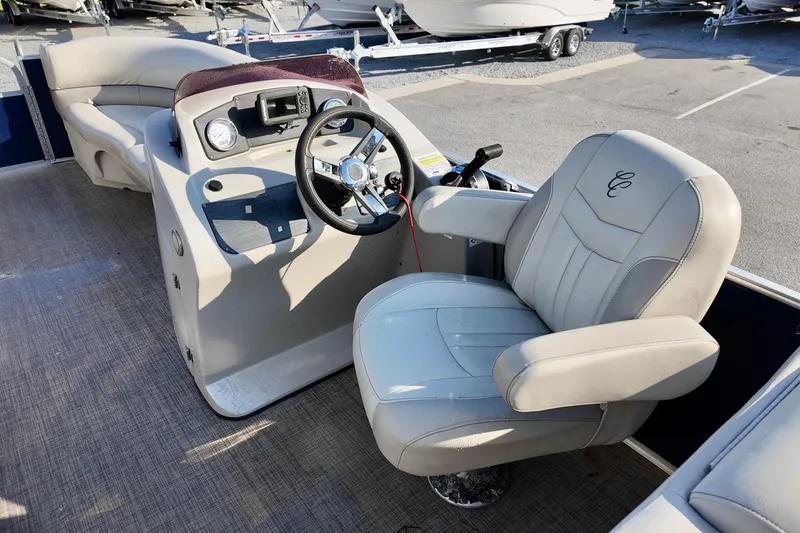 Slide: The Image of 2022 Cypress Cay Seabreeze 232 boat interior with steering wheel and captain's chair. - 5