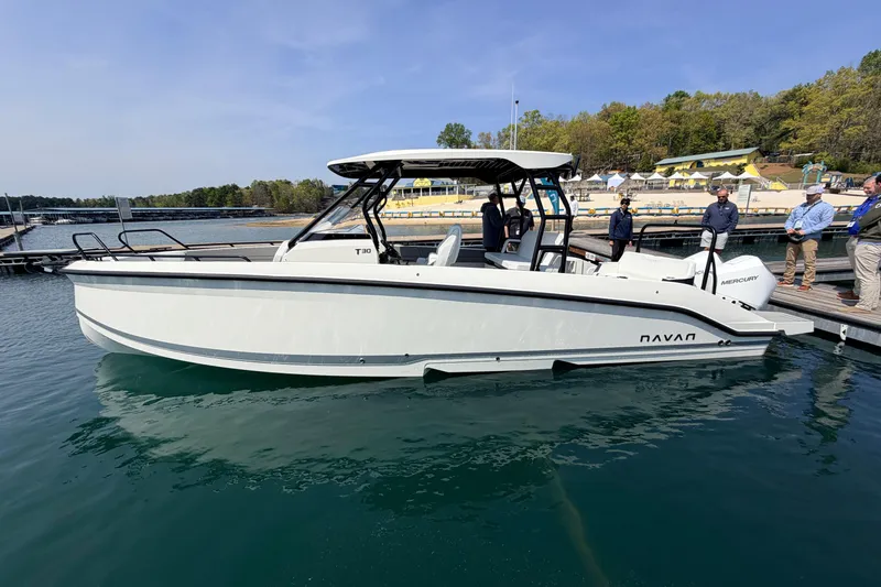 The Image of Navan T30 2027 boat docked on calm water with people nearby. - 0