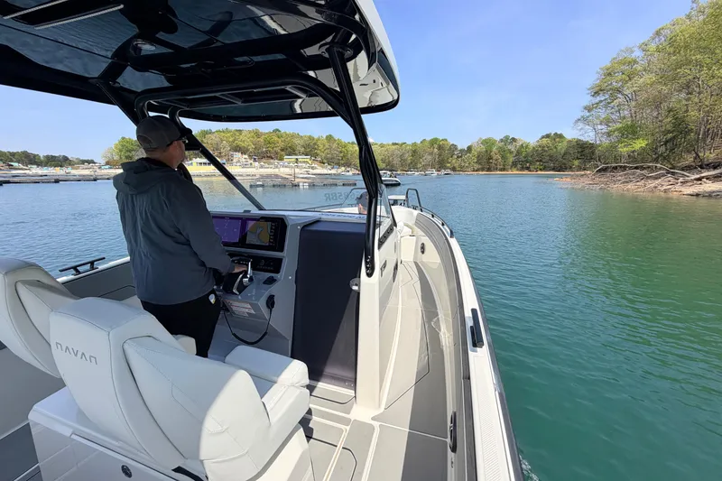 Slide: The Image of Man steering 2027 Navan T30 boat on a serene lake. - 8