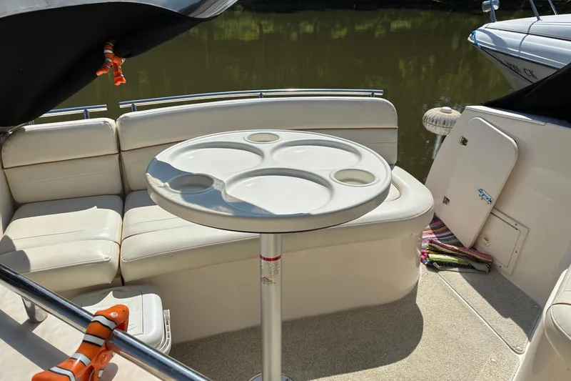 Slide: The Image of 2002 Rinker Fiesta Vee 250 boat interior with seating and round table. - 11