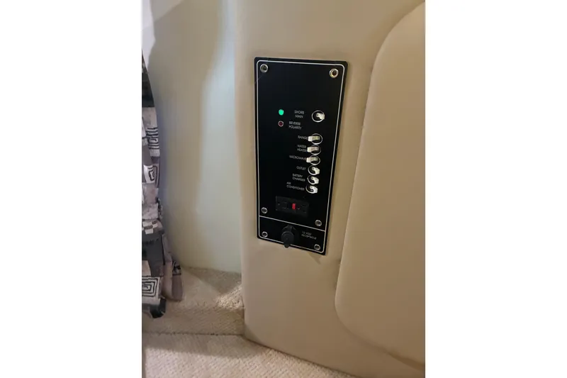 Slide: The Image of Control panel inside 2002 Rinker Fiesta Vee 250 boat, featuring various switches and indicators. - 14