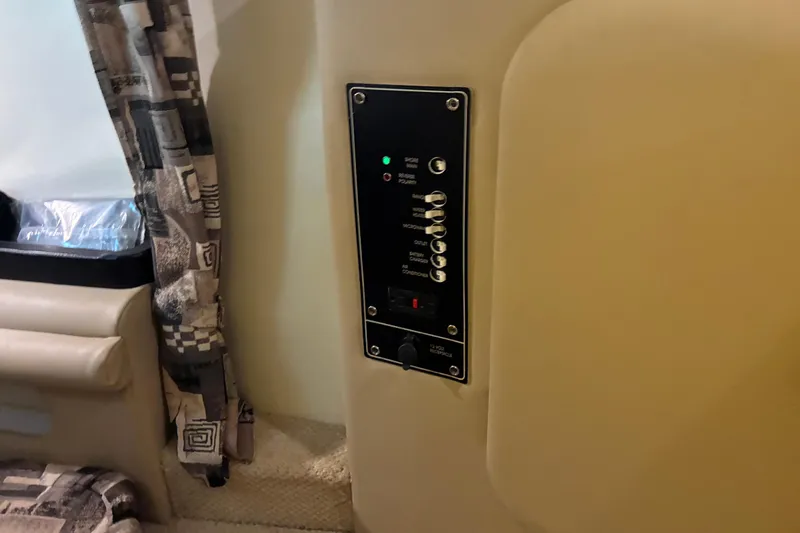 Slide: The Image of Control panel inside 2002 Rinker Fiesta Vee 250 boat cabin, featuring switches and indicators. - 16