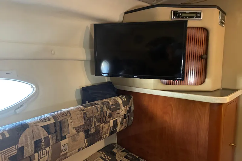 Slide: The Image of Interior of 2002 Rinker Fiesta Vee 250 with TV and patterned seating. - 8