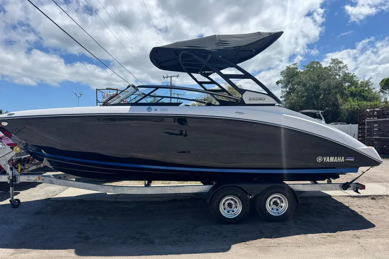 Slide: The Image of 2026 Yamaha Boats 252SD on trailer, sleek design under a partly cloudy sky. - 2