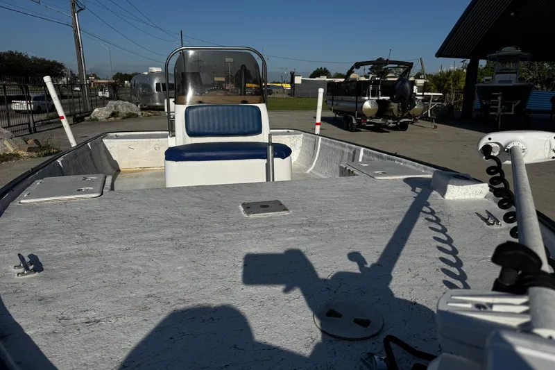 Slide: The Image of 2002 Fishmaster 19 boat with blue seating, parked outdoors under clear sky. - 10