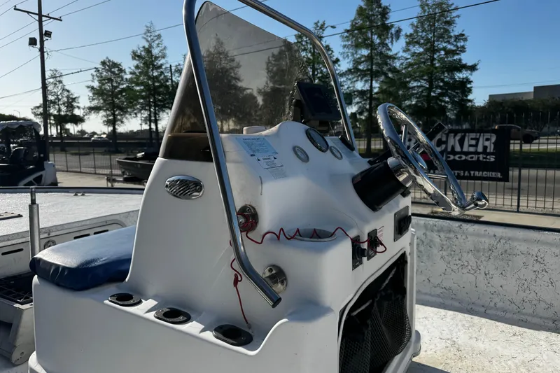 Slide: The Image of 2002 Fishmaster 19 boat console with steering wheel and controls, parked outdoors. - 15
