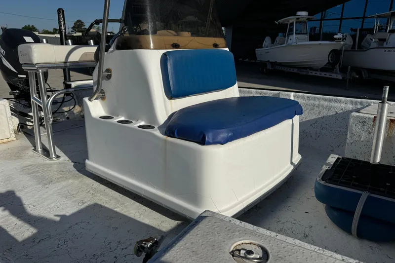 Slide: The Image of 2002 Fishmaster 19 boat interior with blue seating and cup holders. - 16