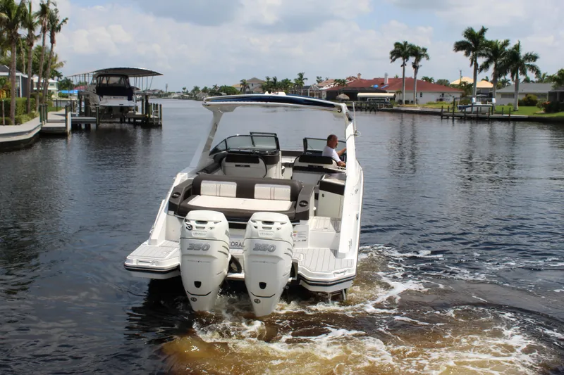 Slide: The Image of 2017 Sea Ray SLX 310 boat on calm water with palm trees in the background. - 20