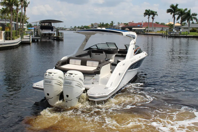 Slide: The Image of 2017 Sea Ray SLX 310 boat on calm water with palm trees in the background. - 21