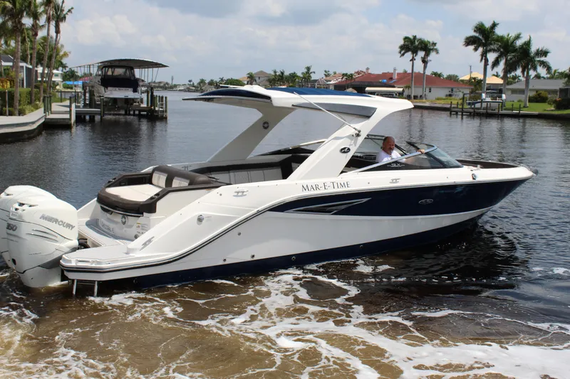 Slide: The Image of 2017 Sea Ray SLX 310 boat on water with palm trees in background. - 23