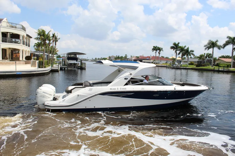 Slide: The Image of 2017 Sea Ray SLX 310 boat on water with palm trees in background. - 24