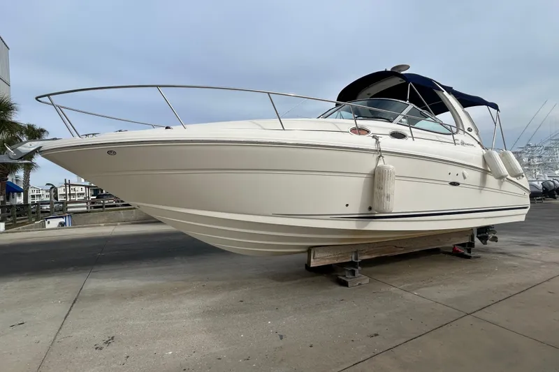 The Image of 2006 Sea Ray 300 Sundancer boat on dry dock, showcasing sleek design and white exterior. - 0