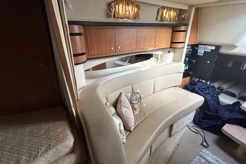 Slide: The Image of Interior of 2006 Sea Ray 300 Sundancer with beige seating and wooden cabinetry. - 12