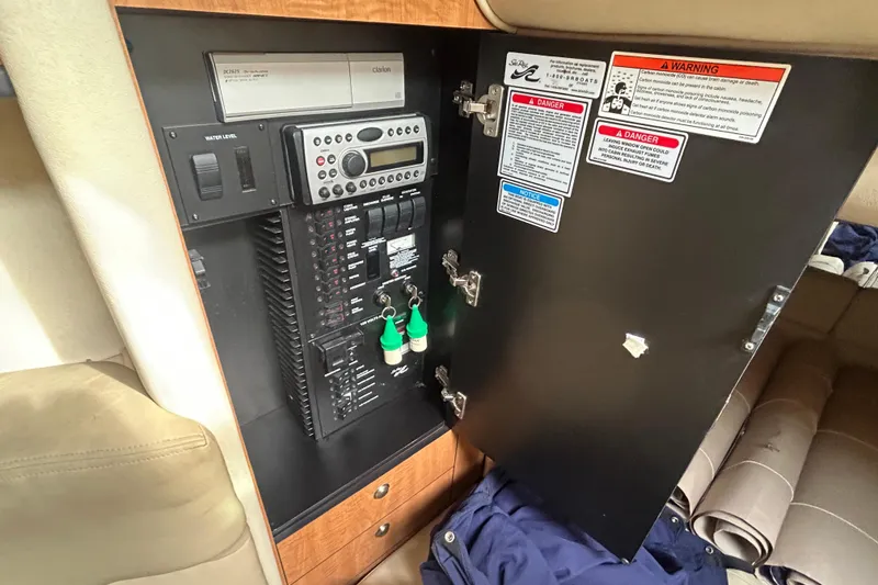 Slide: The Image of Electrical panel inside a 2006 Sea Ray 300 Sundancer boat with warning labels. - 13