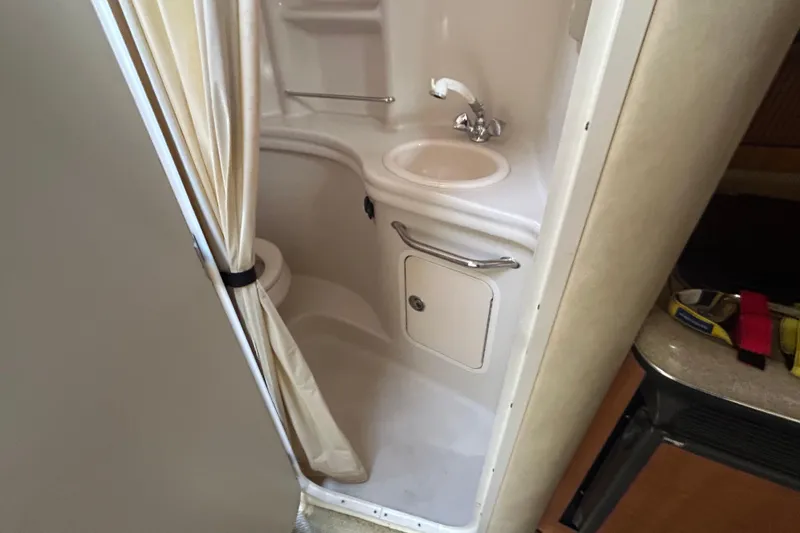 Slide: The Image of Compact bathroom in 2006 Sea Ray 300 Sundancer boat, featuring sink and shower. - 15