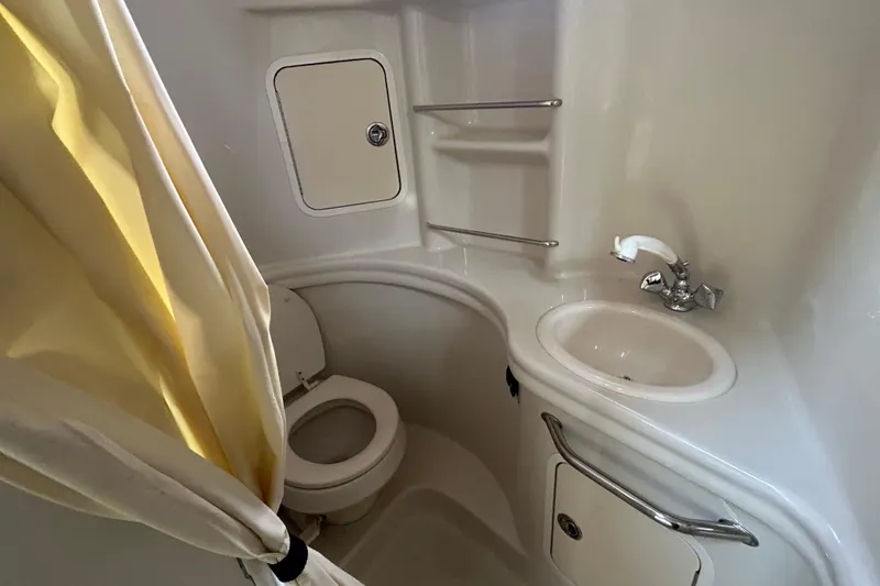 Slide: The Image of Bathroom interior of 2006 Sea Ray 300 Sundancer boat with toilet, sink, and shower curtain. - 16