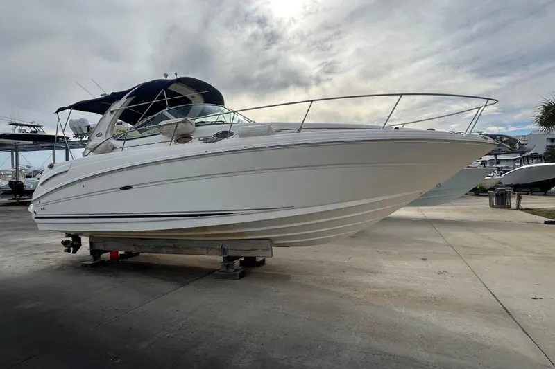 Slide: The Image of 2006 Sea Ray 300 Sundancer boat on dry dock under cloudy sky. - 3