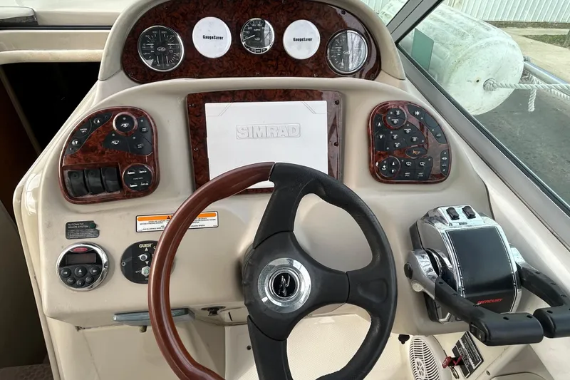 Slide: The Image of 2006 Sea Ray 300 Sundancer helm with steering wheel and control panel. - 8