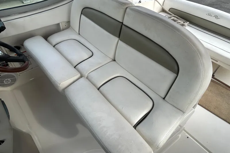 Slide: The Image of 2006 Sea Ray 300 Sundancer interior seating, featuring white and gray upholstery. - 9