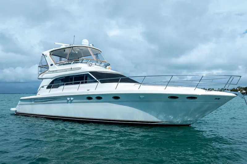 The Image of 2003 Sea Ray 480 Sedan Bridge yacht on calm waters under cloudy skies. - 0