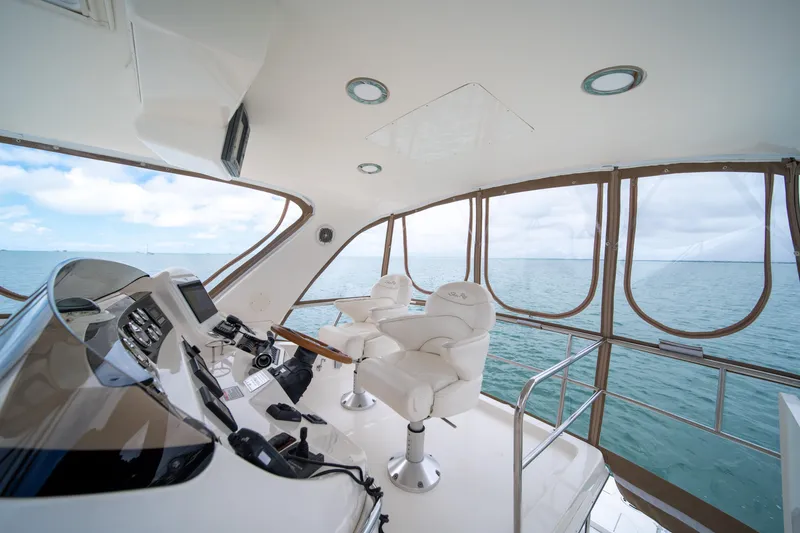 Slide: The Image of 2003 Sea Ray 480 Sedan Bridge helm with ocean view, featuring luxurious seating and controls. - 11