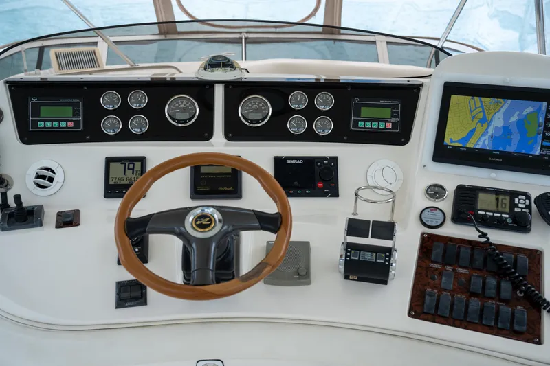 Slide: The Image of 2003 Sea Ray 480 Sedan Bridge helm with navigation instruments and steering wheel. - 13