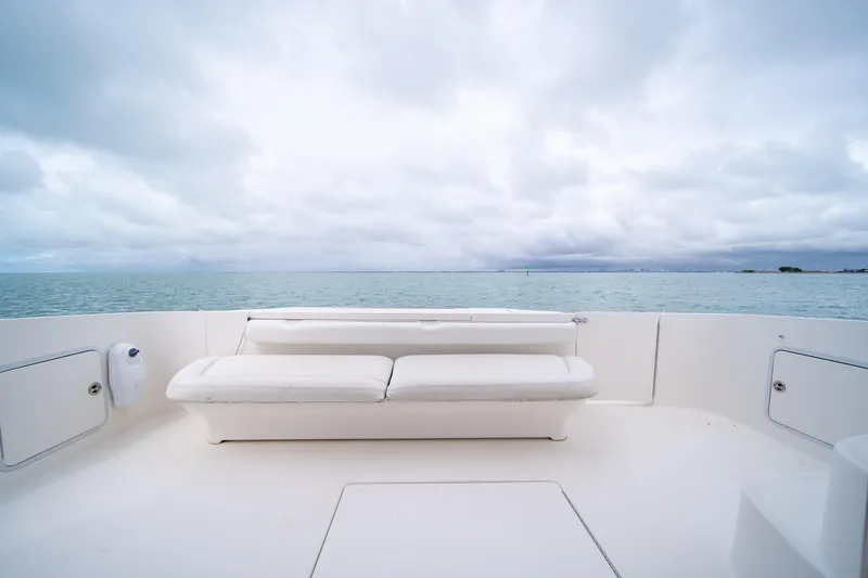 Slide: The Image of 2003 Sea Ray 480 Sedan Bridge yacht deck with ocean view and white seating. - 14