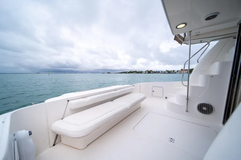 Slide: The Image of 2003 Sea Ray 480 Sedan Bridge yacht deck with seating, overlooking calm waters. - 15