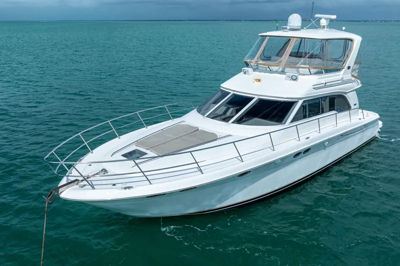 Slide: The Image of 2003 Sea Ray 480 Sedan Bridge yacht on calm blue waters. - 2