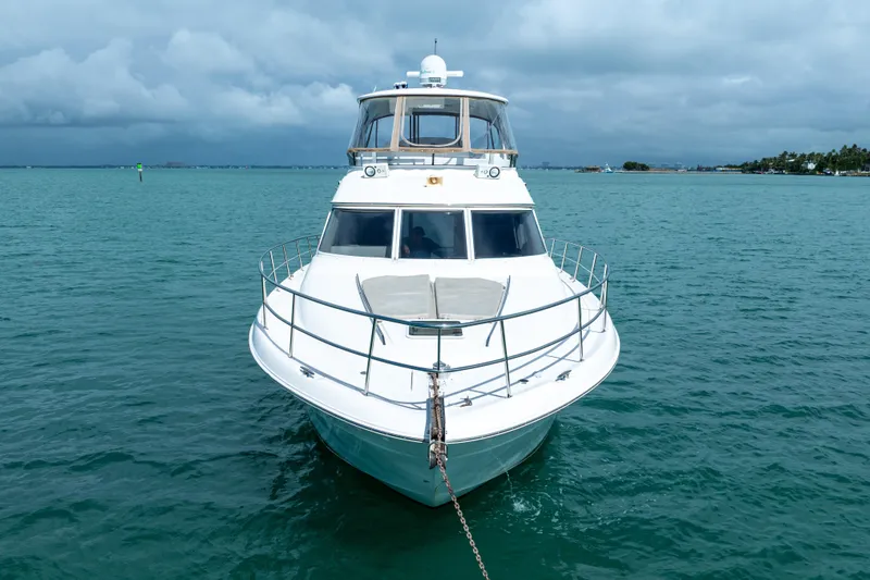Slide: The Image of 2003 Sea Ray 480 Sedan Bridge yacht anchored on calm blue waters. - 3