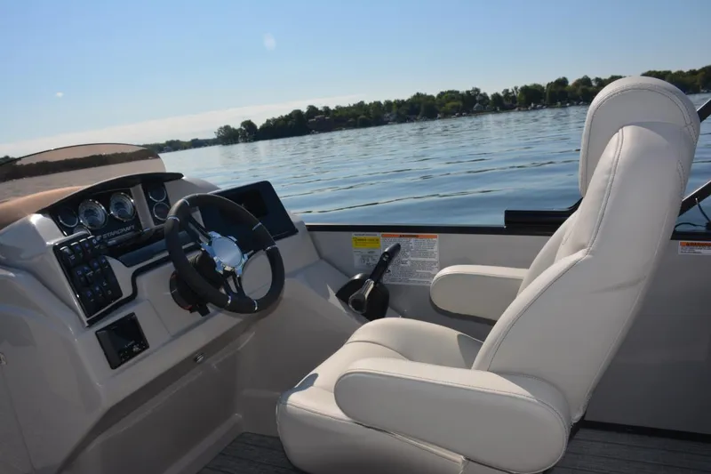 Slide: The Image of Manufacturer Provided Image: 2022 Starcraft CX 23 Q boat interior with captain's chair and steering console. - 6