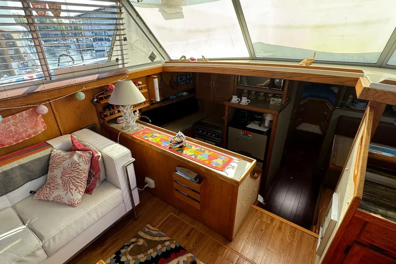 Slide: The Image of Interior of a 1985 Silverton 40 Aft Cabin yacht with cozy seating and kitchen area. - 16