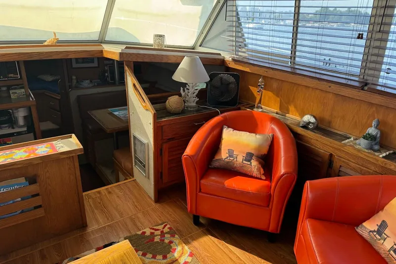 Slide: The Image of Interior of 1985 Silverton 40 Aft Cabin with orange chairs and nautical decor. - 18