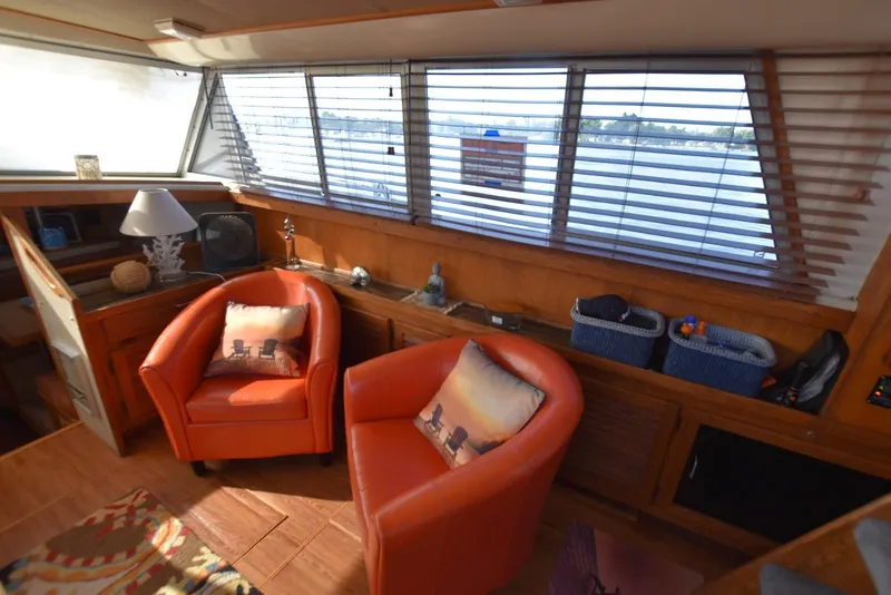 Slide: The Image of Interior of 1985 Silverton 40 Aft Cabin with orange chairs and nautical decor. - 19