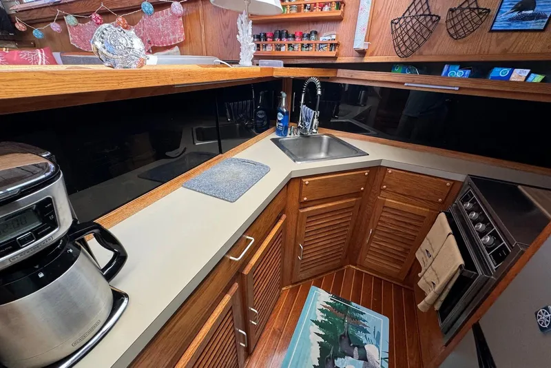 Slide: The Image of 1985 Silverton 40 Aft Cabin kitchen with wooden cabinets, sink, and appliances. - 24