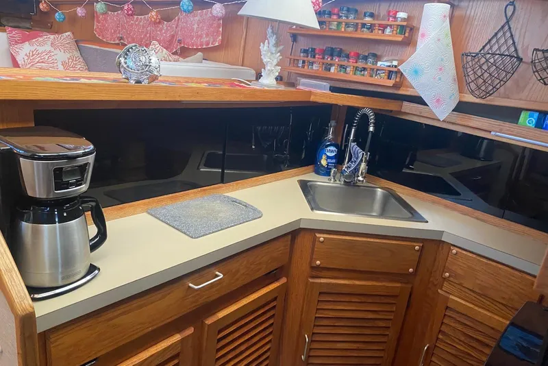 Slide: The Image of 1985 Silverton 40 Aft Cabin kitchen with sink, coffee maker, and spice rack. - 25