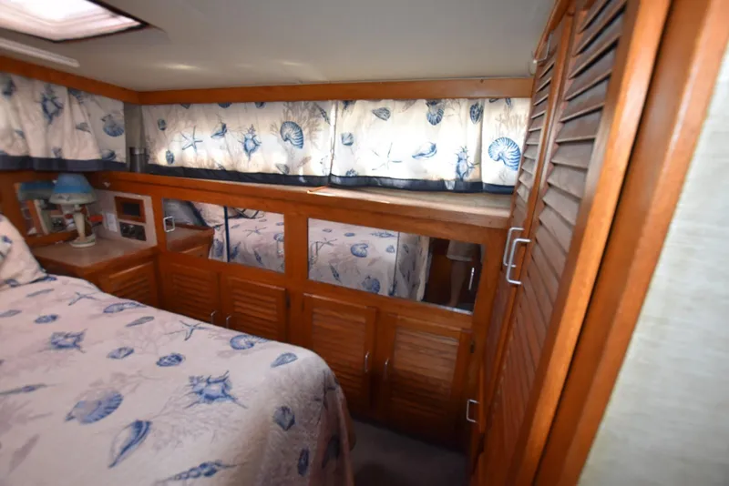 Slide: The Image of 1985 Silverton 40 Aft Cabin interior with nautical-themed decor and wooden cabinetry. - 30