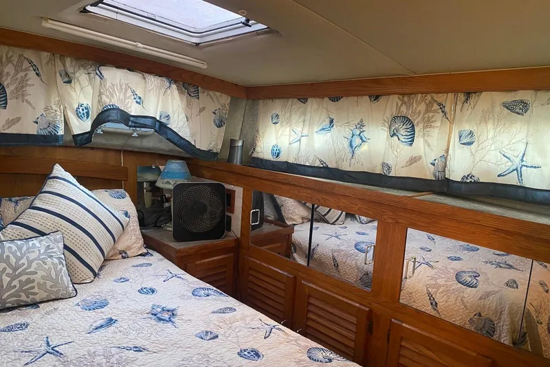 Slide: The Image of Cozy 1985 Silverton 40 Aft Cabin bedroom with nautical-themed decor and natural light. - 31