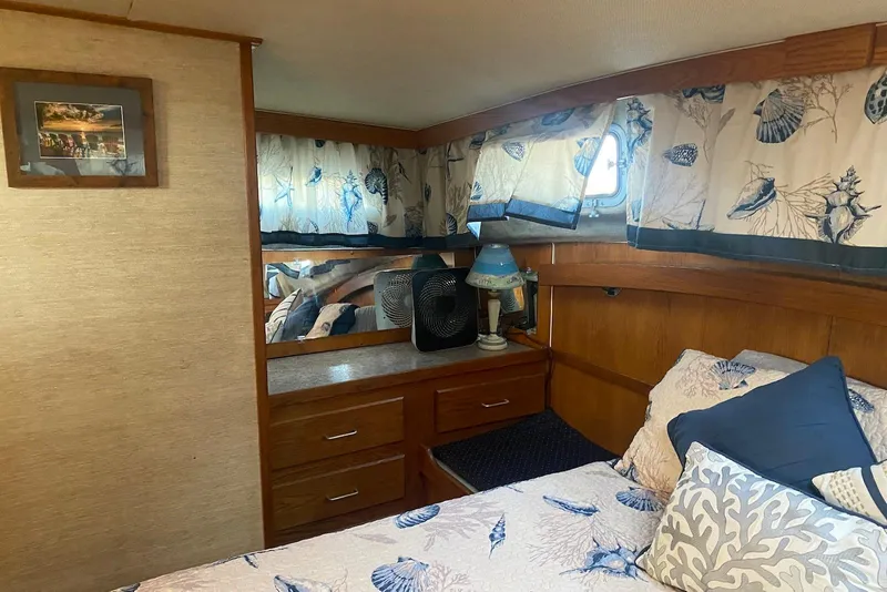 Slide: The Image of 1985 Silverton 40 Aft Cabin bedroom with nautical decor and wooden furnishings. - 32