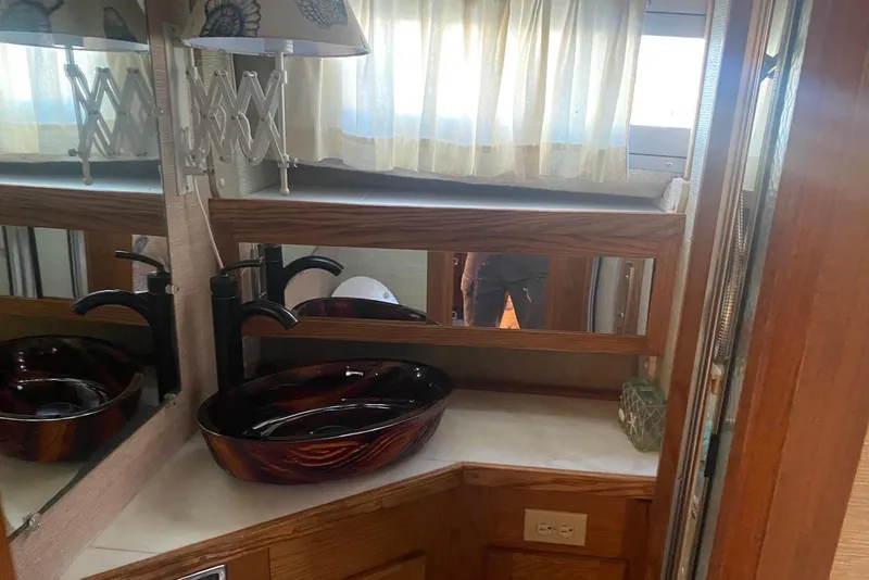 Slide: The Image of 1985 Silverton 40 Aft Cabin bathroom with vessel sink and mirrored vanity. - 34