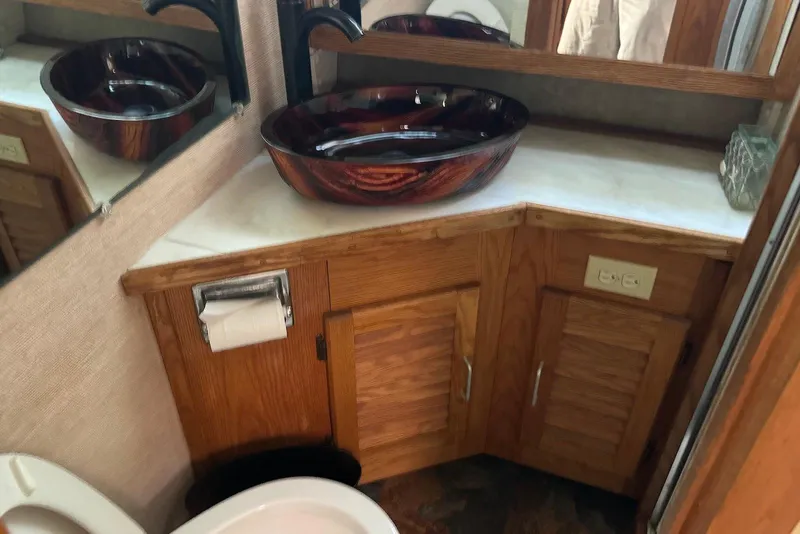 Slide: The Image of 1985 Silverton 40 Aft Cabin bathroom with wooden cabinetry and stylish vessel sink. - 35