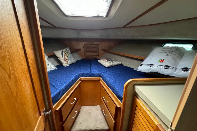 Slide: The Image of 1985 Silverton 40 Aft Cabin interior with blue bedding and wooden cabinetry. - 36