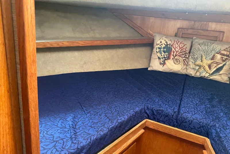 Slide: The Image of Interior of 1985 Silverton 40 Aft Cabin with blue bedding and nautical-themed pillows. - 38