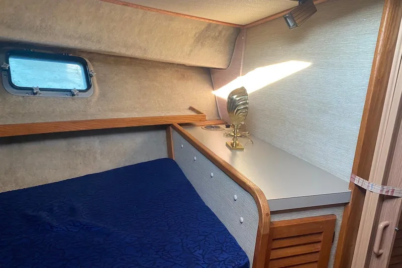 Slide: The Image of 1985 Silverton 40 Aft Cabin interior with cozy bed, wooden accents, and natural light. - 39