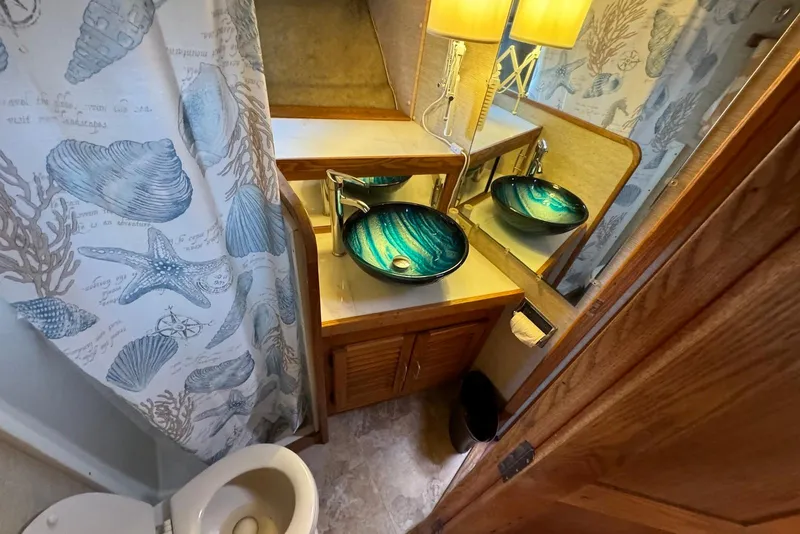 Slide: The Image of 1985 Silverton 40 Aft Cabin bathroom with nautical decor and blue vessel sink. - 42