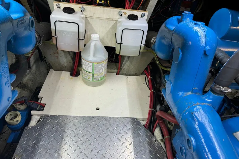 Slide: The Image of Engine room of 1985 Silverton 40 Aft Cabin with blue machinery and containers. - 46